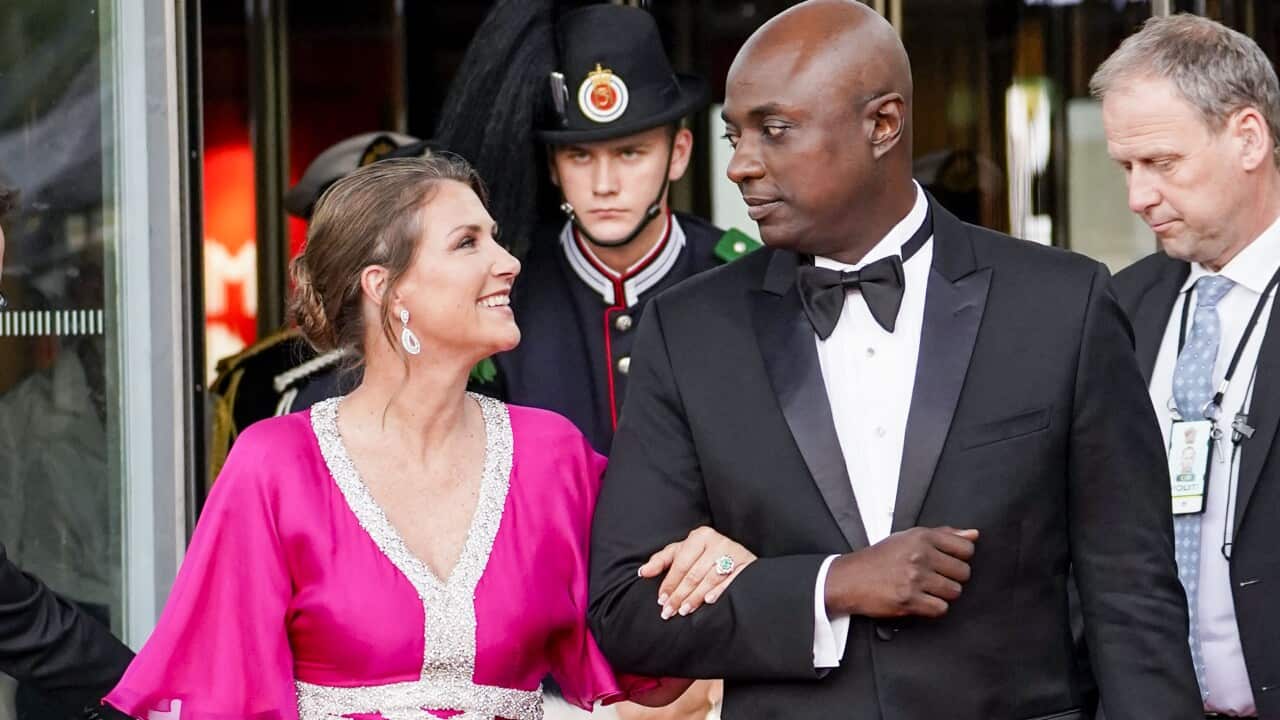 A man and a woman walking with their arms linked.