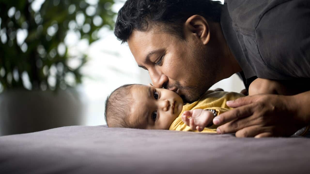 Father kissing his baby son at home