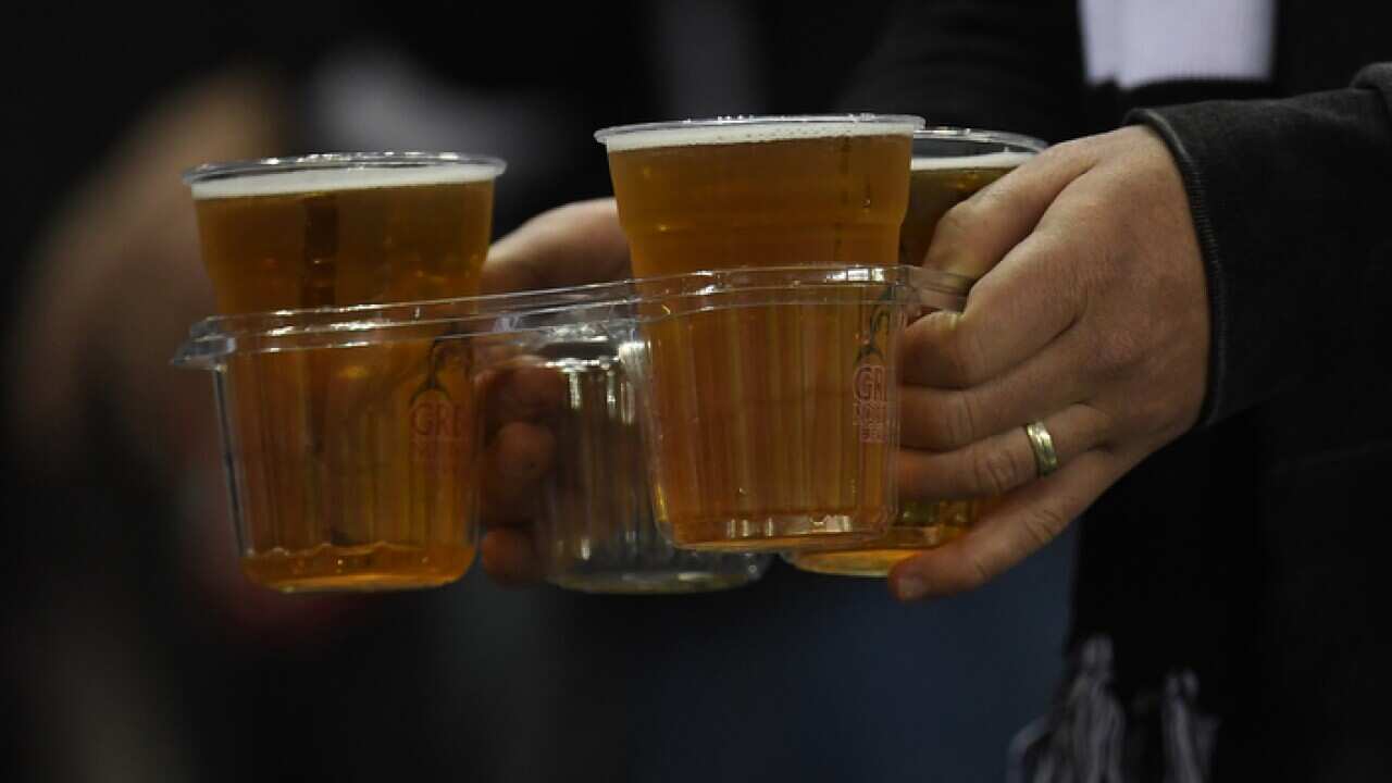 A fan is seen carrying beer before during the Round 9 AFL match