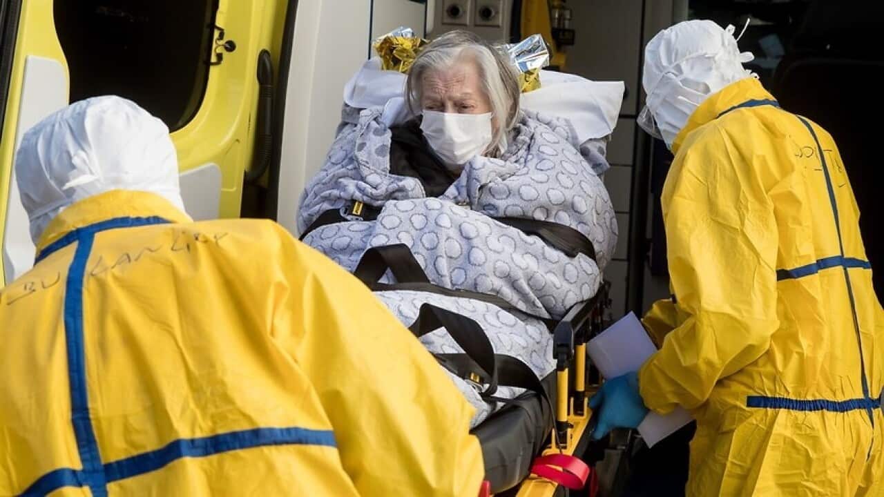A patient potentially infected with COVID-19 coronavirus lays on a stretcher before being transported in Brussels, Belgium