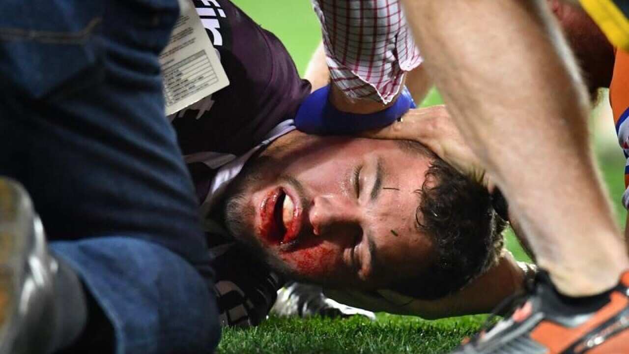 Corey Oates of the Broncos lies injured on the field