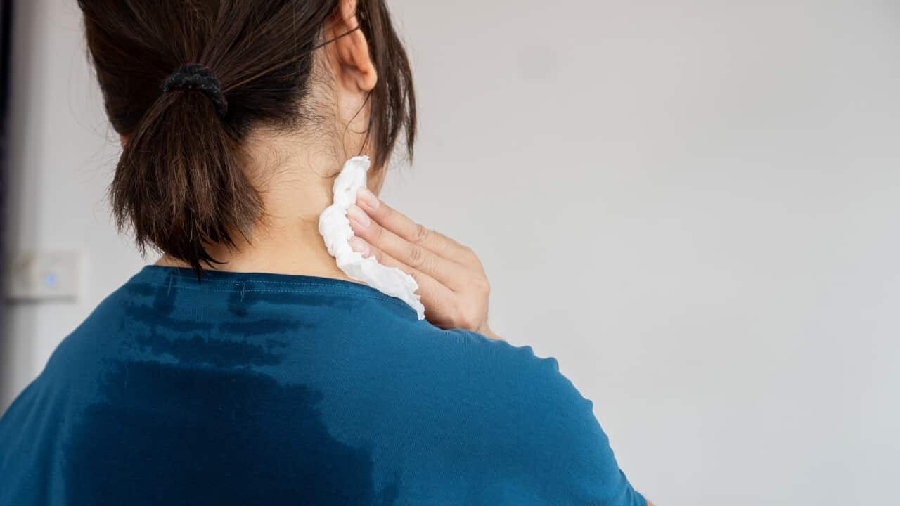 Back view of sweating woman with wet cloth because of hot weather in summer time,