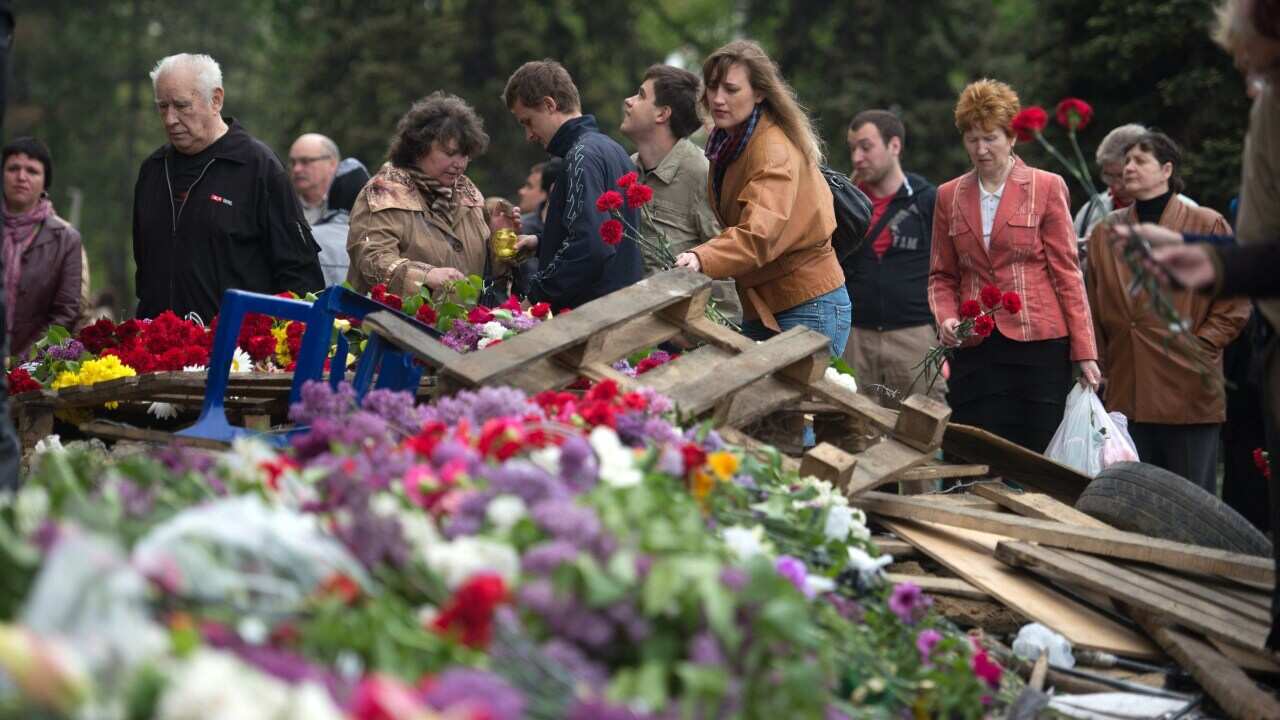 People lay flowers for victims at the burned trade union building in Odessa getty-1.jpg