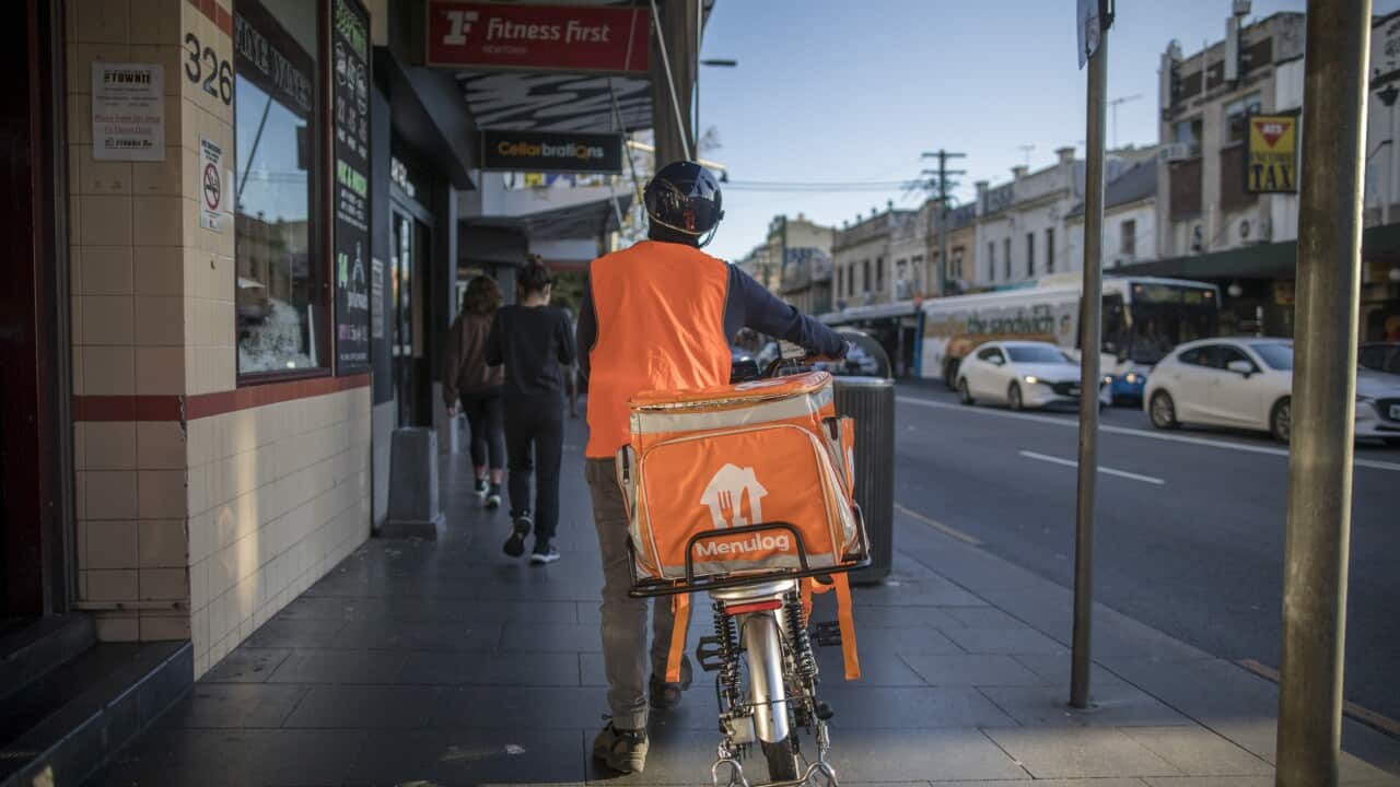A food delivery courier with a Menulog branded bag in the Newtown area of Sydney