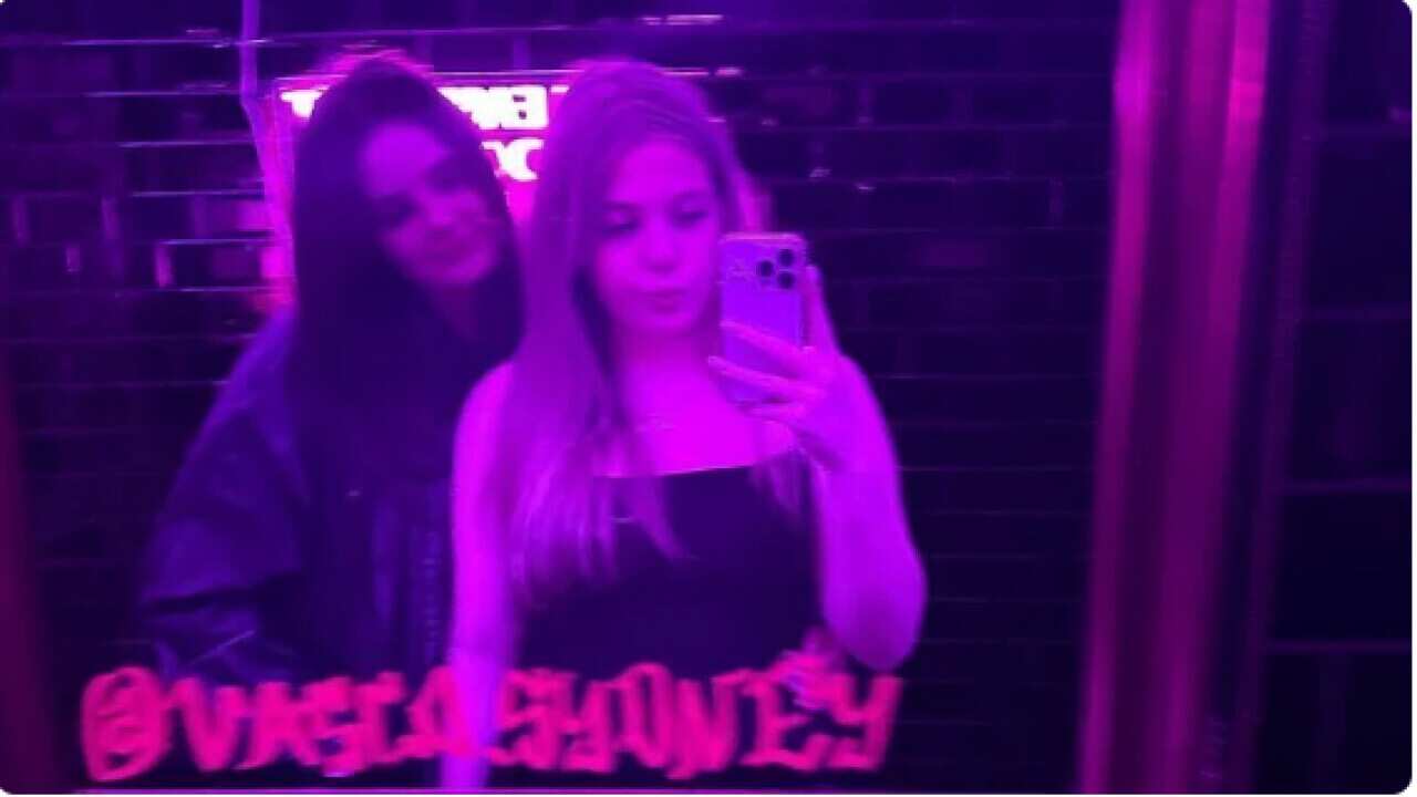 Two teenage girls taking a photo in the mirror