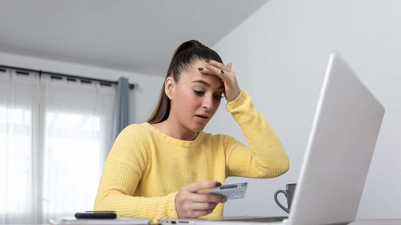 Anxious woman with credit card shopping online