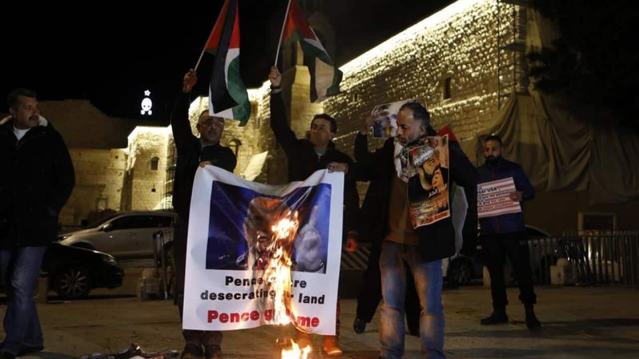 Palestinians burn a poster of US Vice President Mike Pence