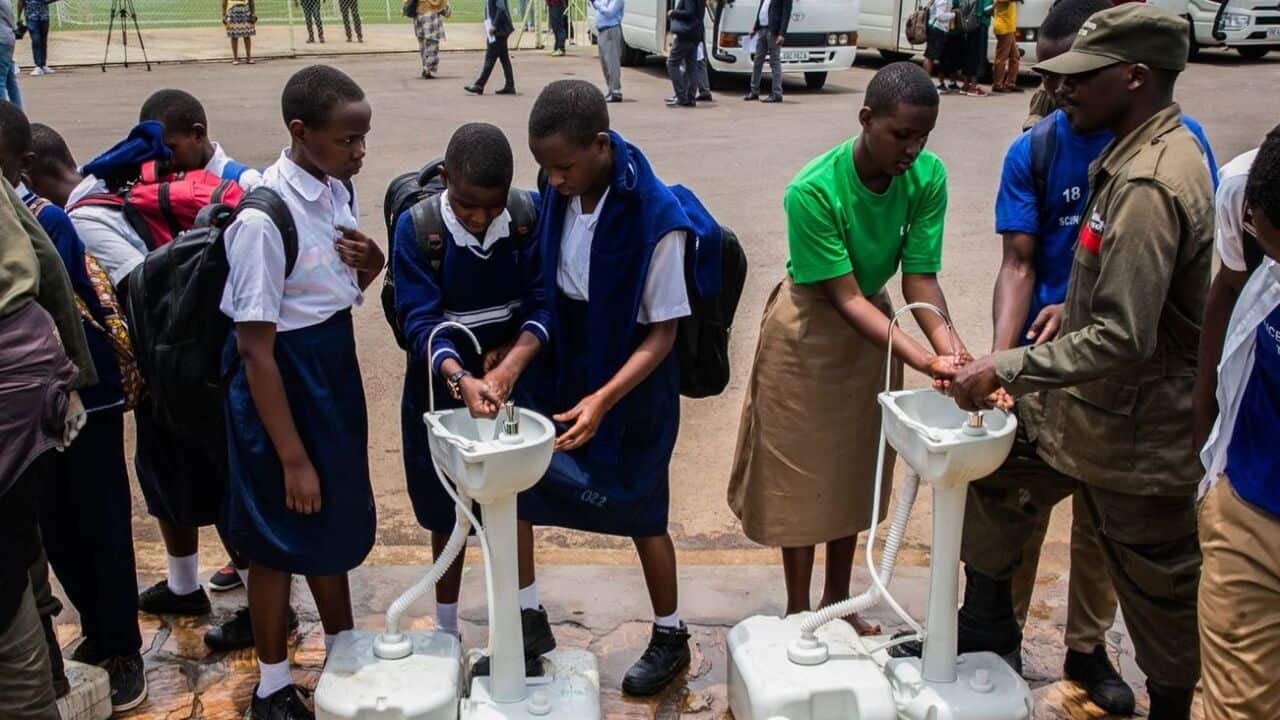 Secondary school students wash their hands at temporary hand washing point before they return home as Rwandan Government decided to send back home all students.