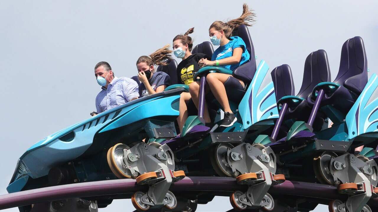 Sea World guests with masks ride a roller coaster in Orlando, Florida. Florida is the new COVID-19 hotspot in the USA where the restrictions have eased.