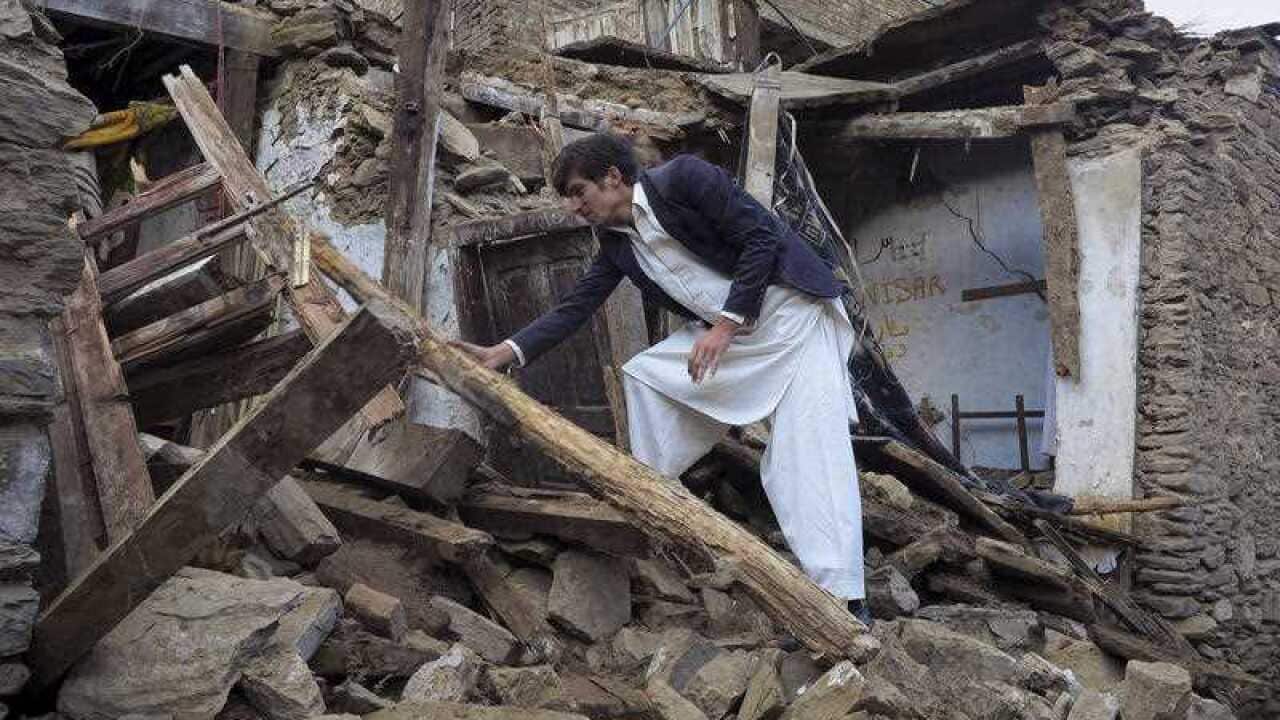 A Pakistani boy examines a house damaged caused by massive earthquake in Mingora, the main town of Swat valley
