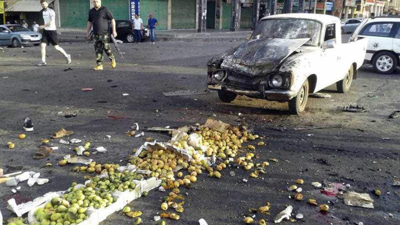 In this photo released by the Syrian official news agency SANA, Syrians inspect the site of a suicide attack in Sweida, Syria, Wednesday, July 25, 2018.