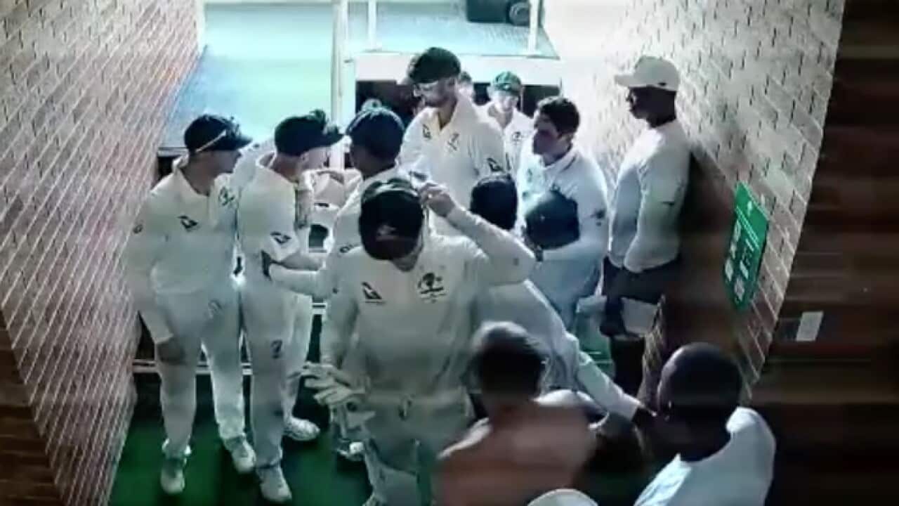 Members of the Australian cricket side restrain David Warner as the team breaks for tea on day four of the first Test against South Africa
