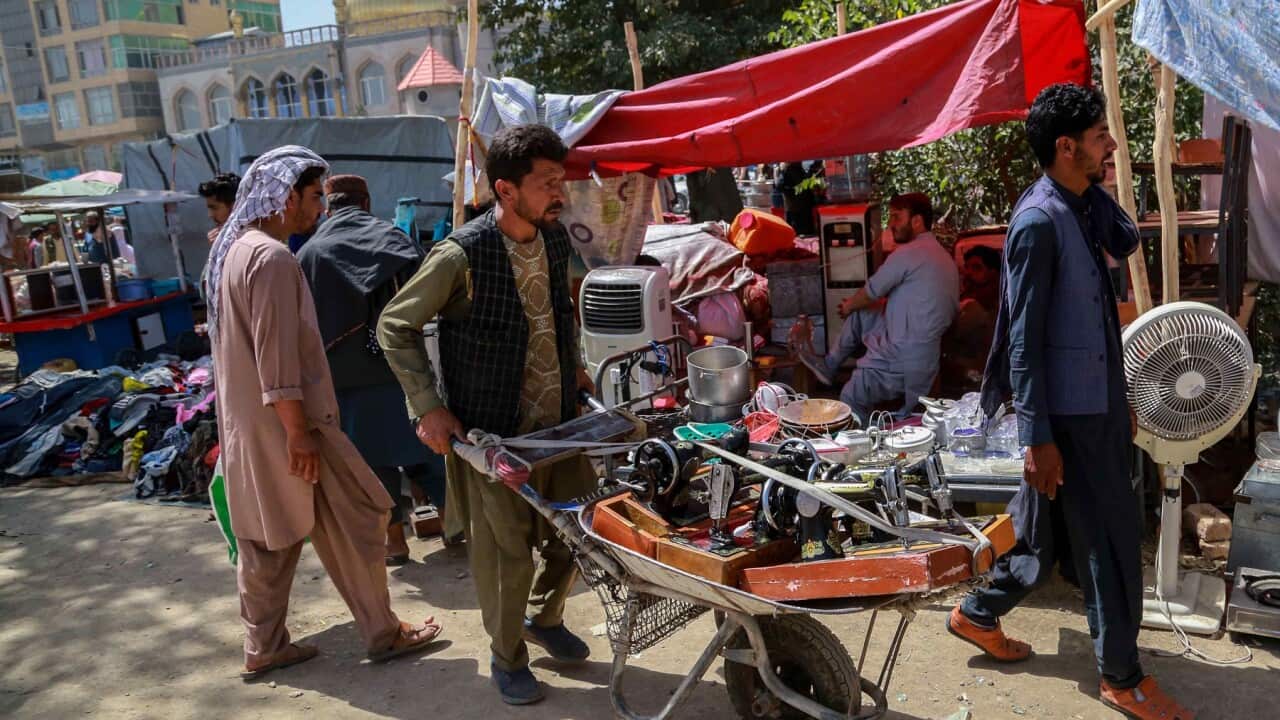 An Afghan man sells his household items to raise money to buy food