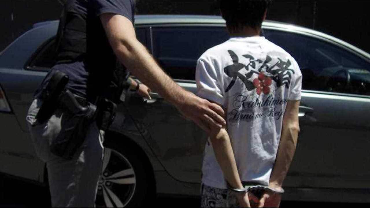 Australian Border Force officials arresting a male Chinese national in relation to an international organised tobacco smuggling syndicate. 
