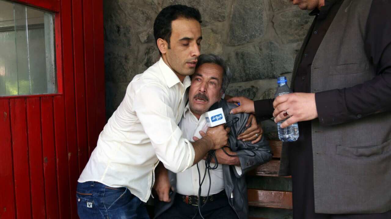 A man cries at a hospital after he lost his Journalist son in explosions in Kabul, Afghanistan, Monday, April 30, 2018. A coordinated double suicide bombing hit central Kabul on Monday morning, (AP Photo/Rahmat Gul)