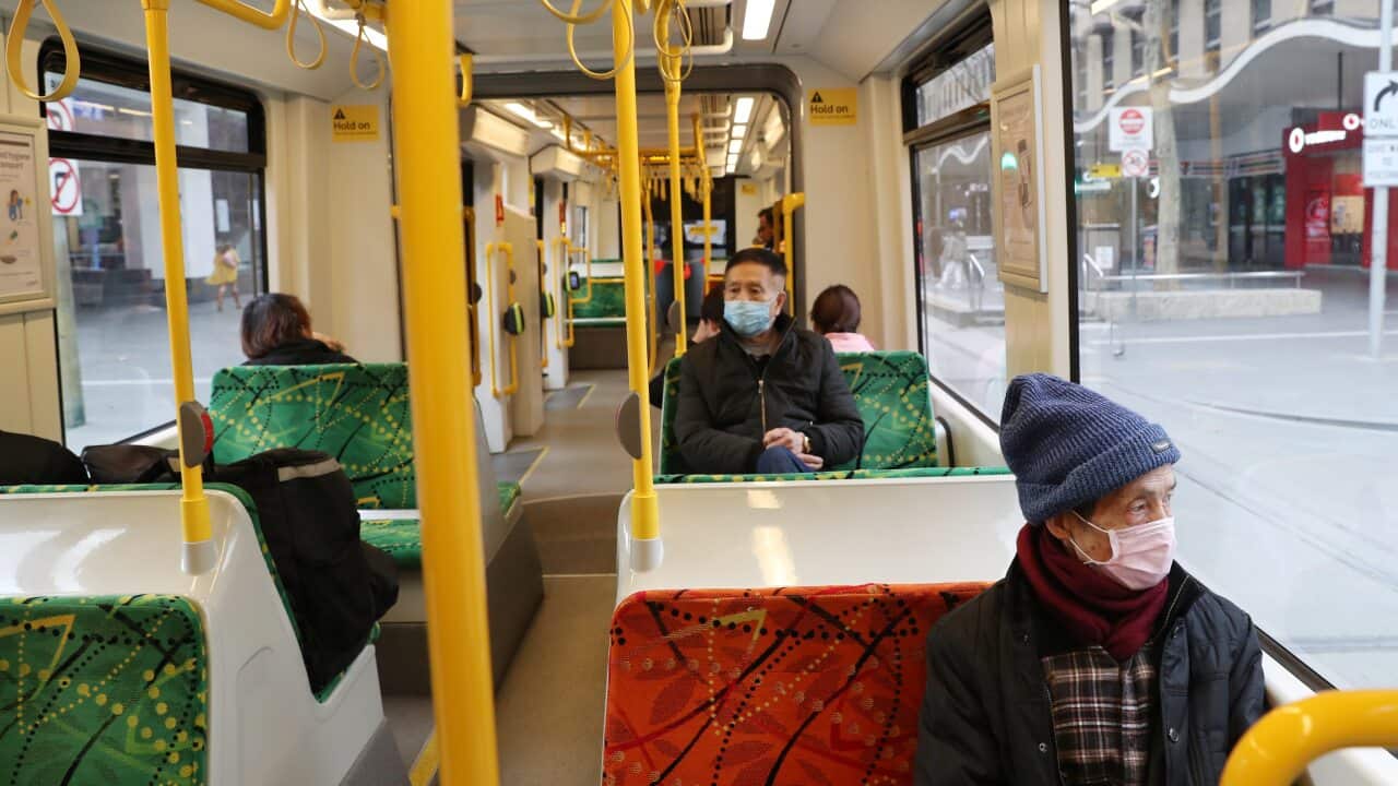 A man wears a mask on a tram travelling down Bourke street in Melbourne.