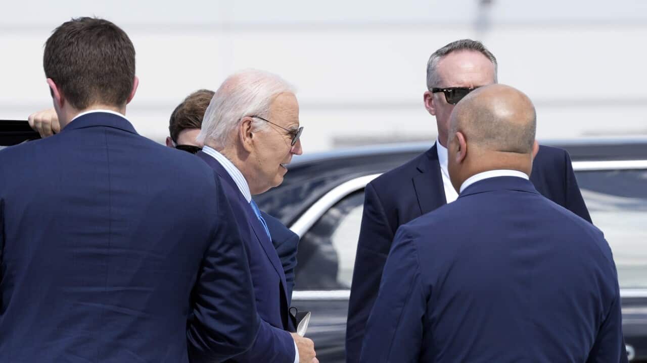 Il Presidente statunitense Joe Biden con una mascherina in mano mentre si imbarca sull'Air Force One.