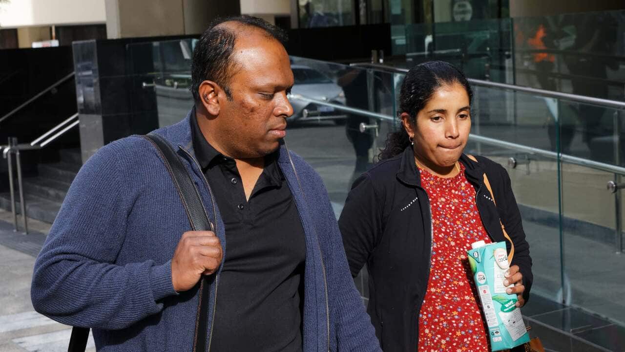 A South Asian man and woman walking side-by-side