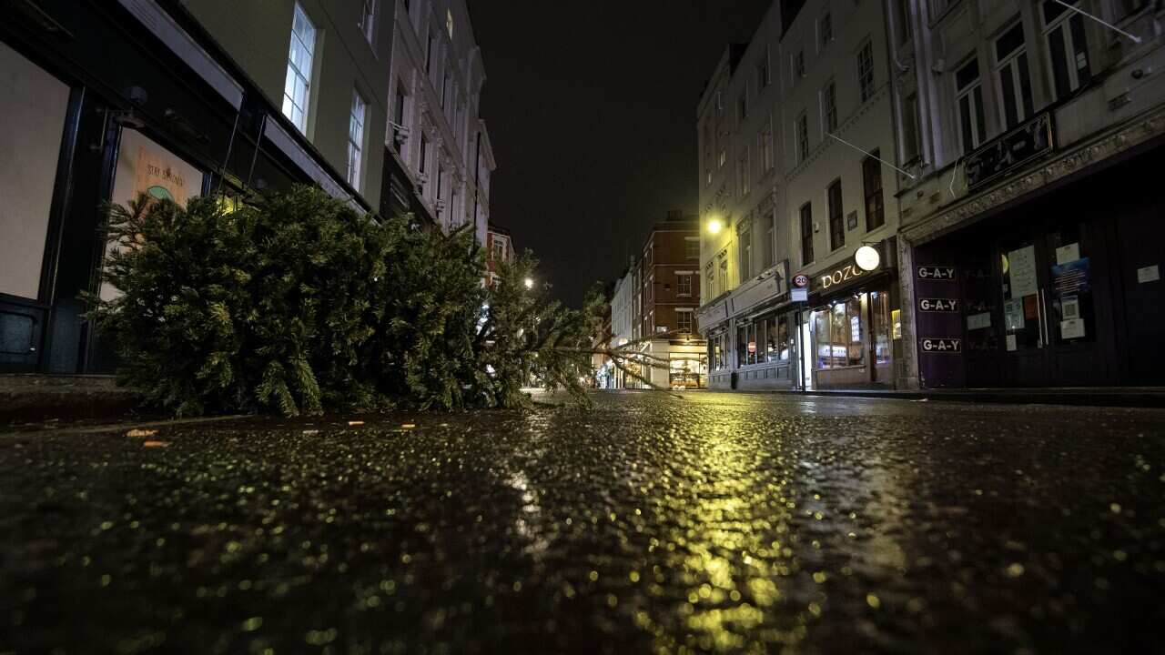 A discarded Christmas tree lies outside closed pubs and theatres in a deserted Old Compton Street in London