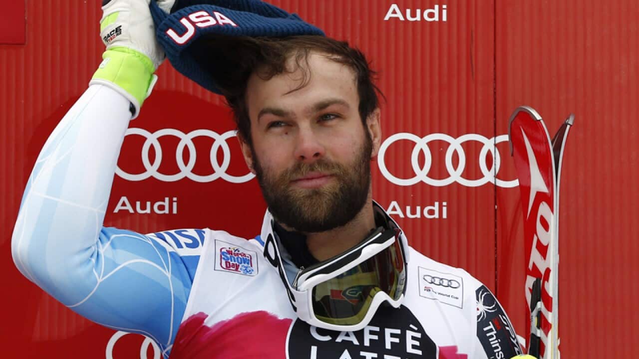 Travis Ganong stands on the podium after winning an alpine ski