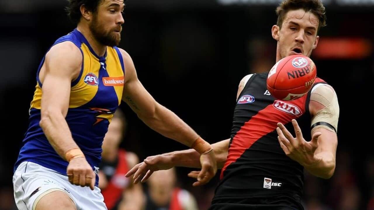 Michael Hartley of the Bombers makes a catch past Josh Kennedy.