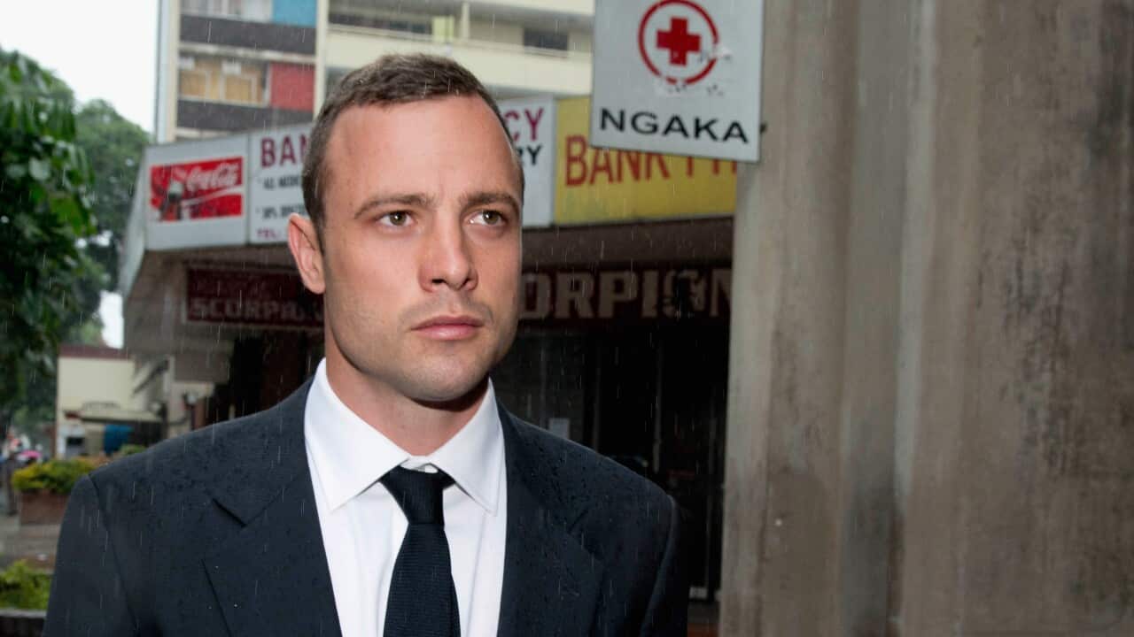 Oscar Pistorius is seen in a suit and tie walking on the street.
