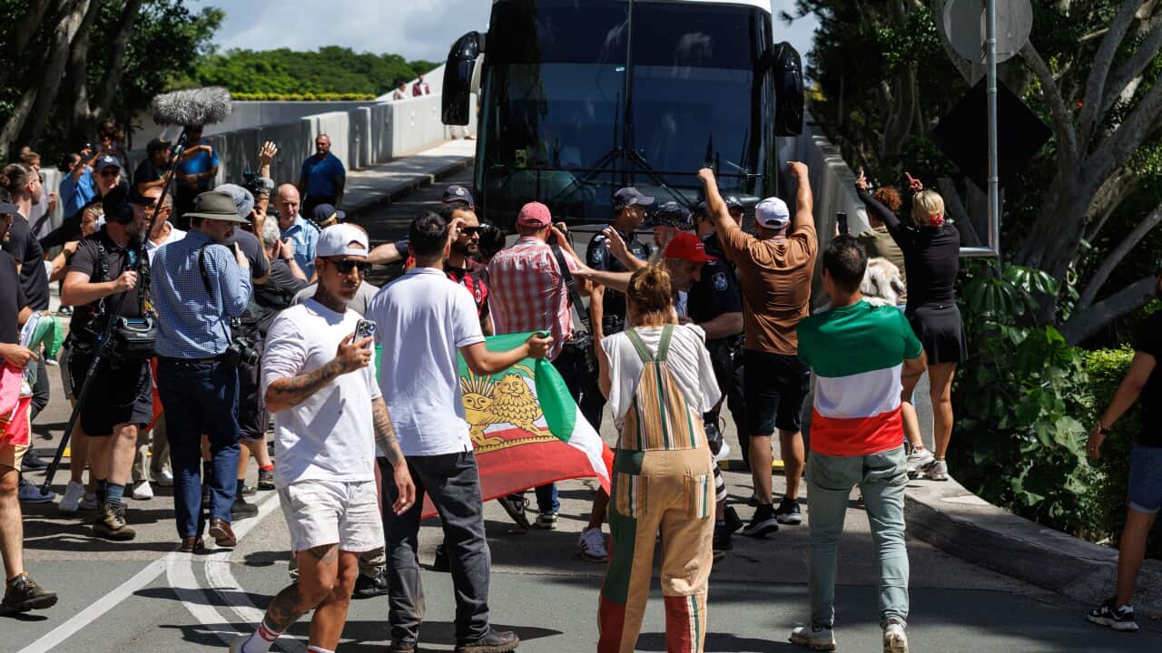 A group of protesters blocking off a bus.