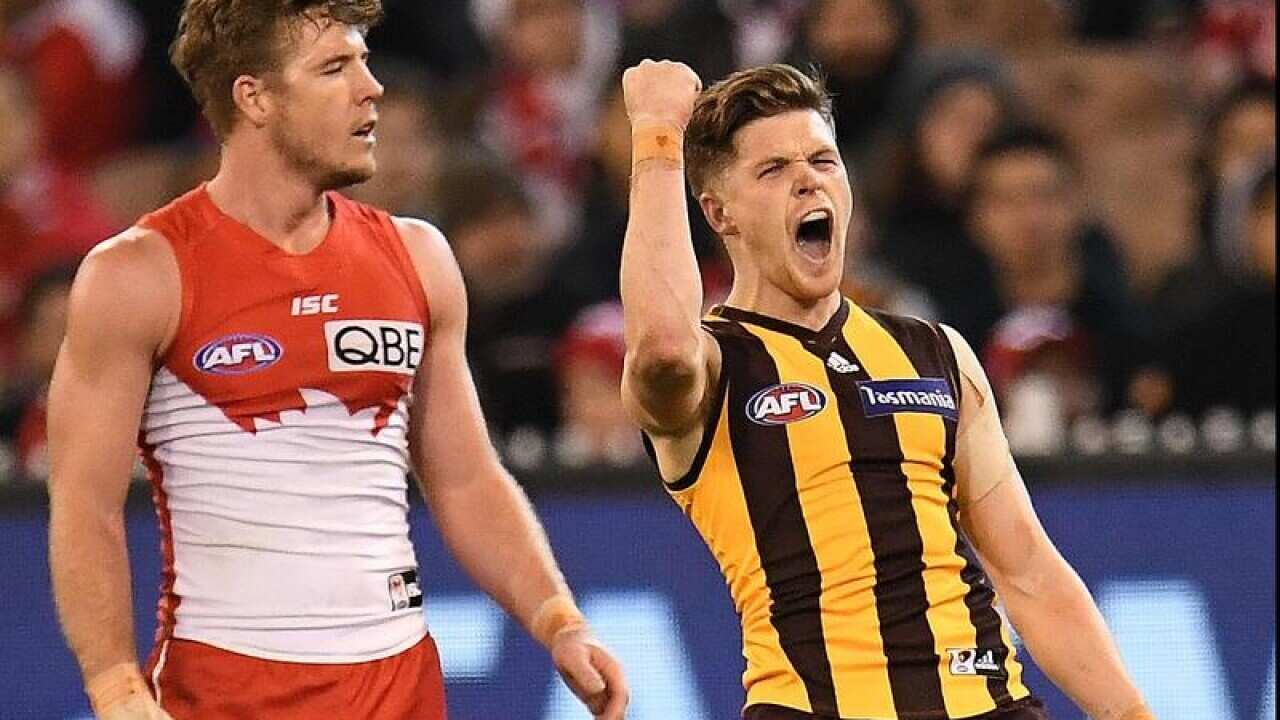 Taylor Duryea of the Hawks (R) reacts after kicking a goal