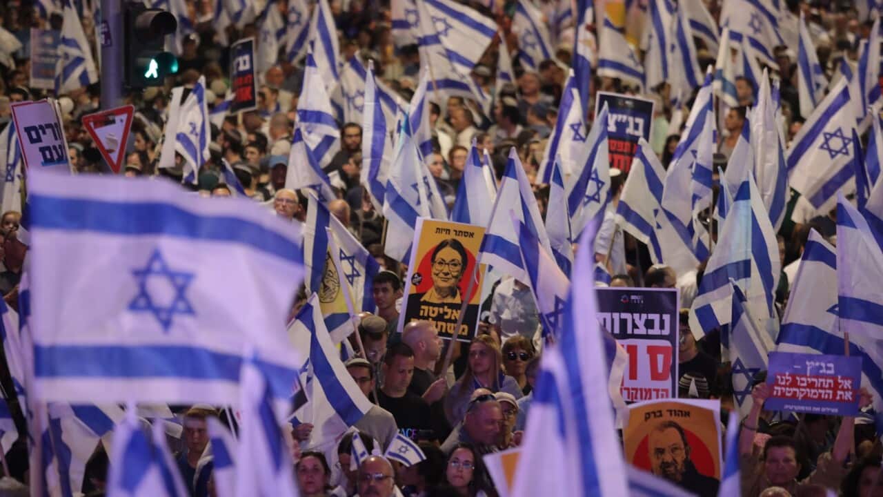 Protesters hold signs and flags.