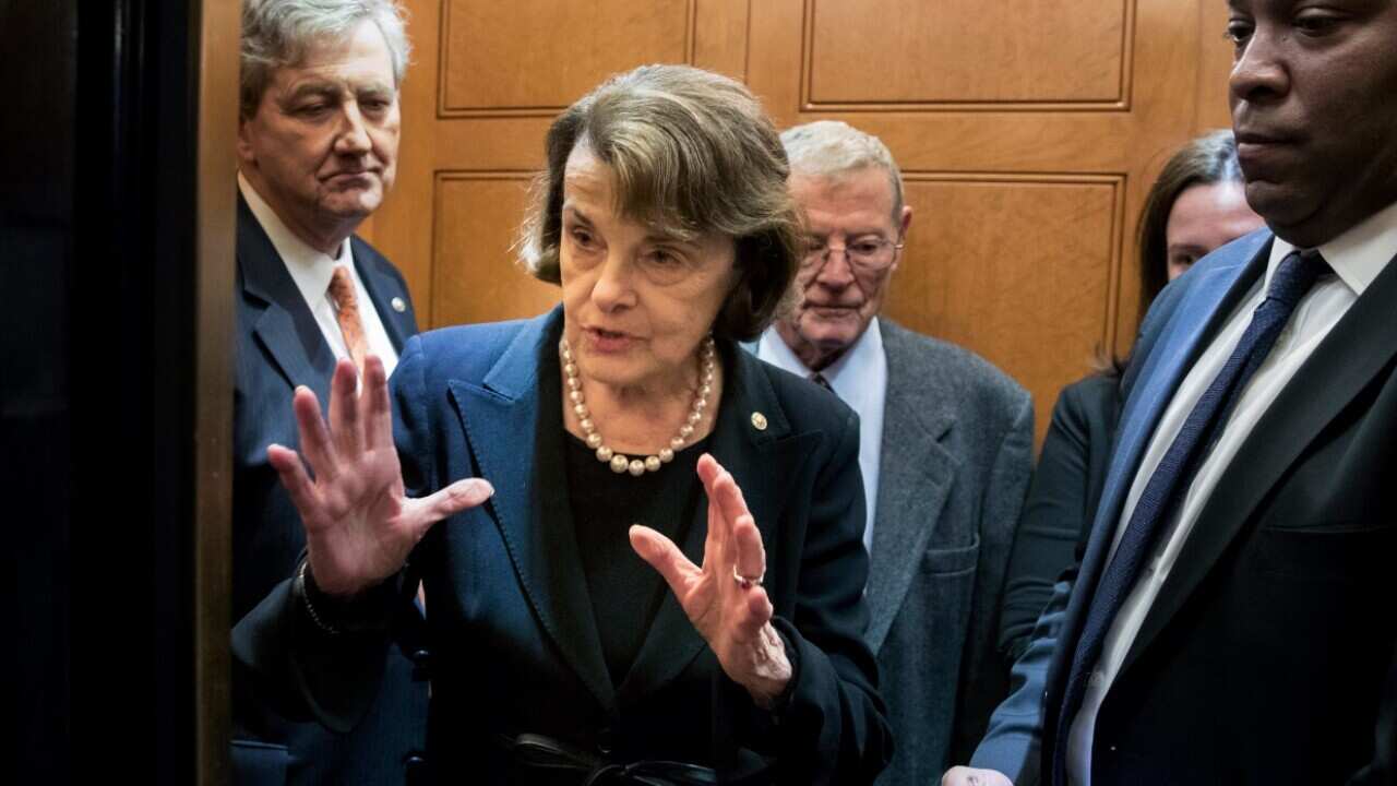 Democratic Senator from California Dianne Feinstein (C) speaks to a reporter after entering an elevator near the Senate floor on Capitol Hill