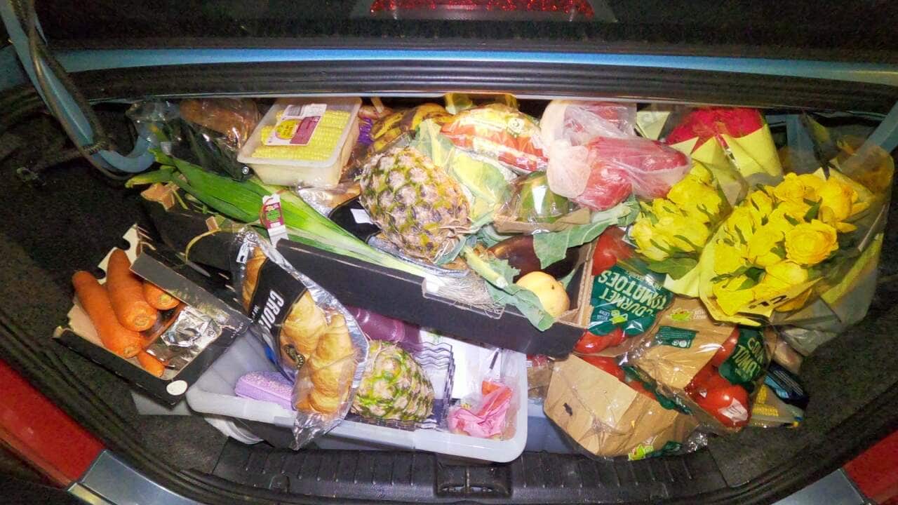 A car boot full with grocery items.
