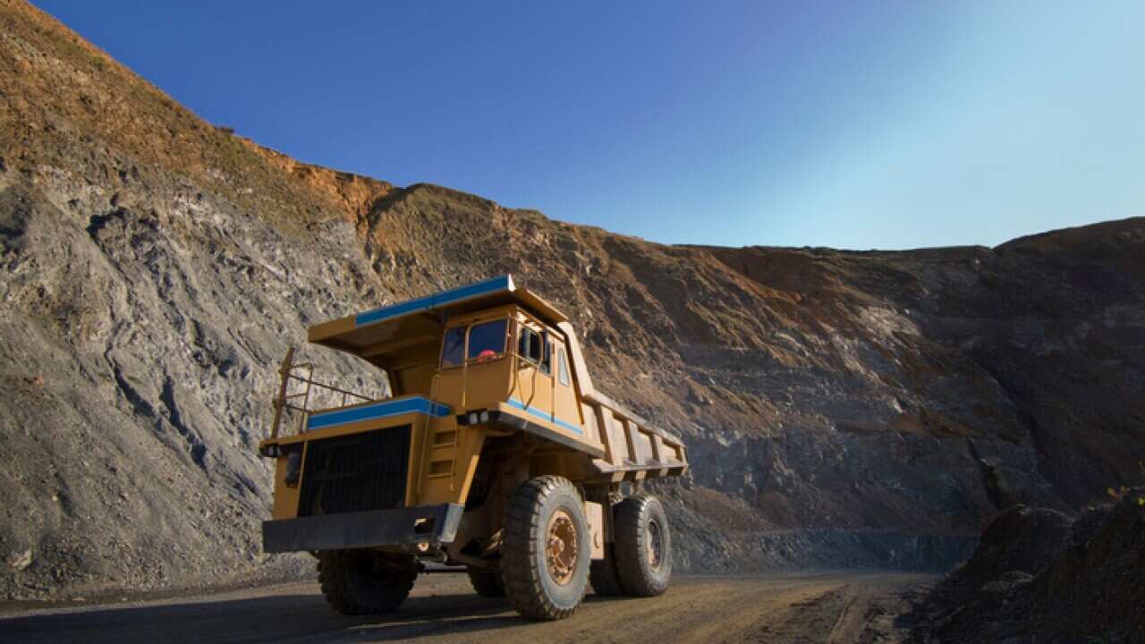 Large dump trucks on quarry road.