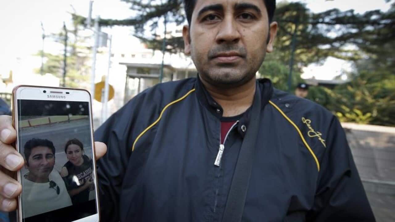 Mirza Imran Baig shows with a picture of his wife