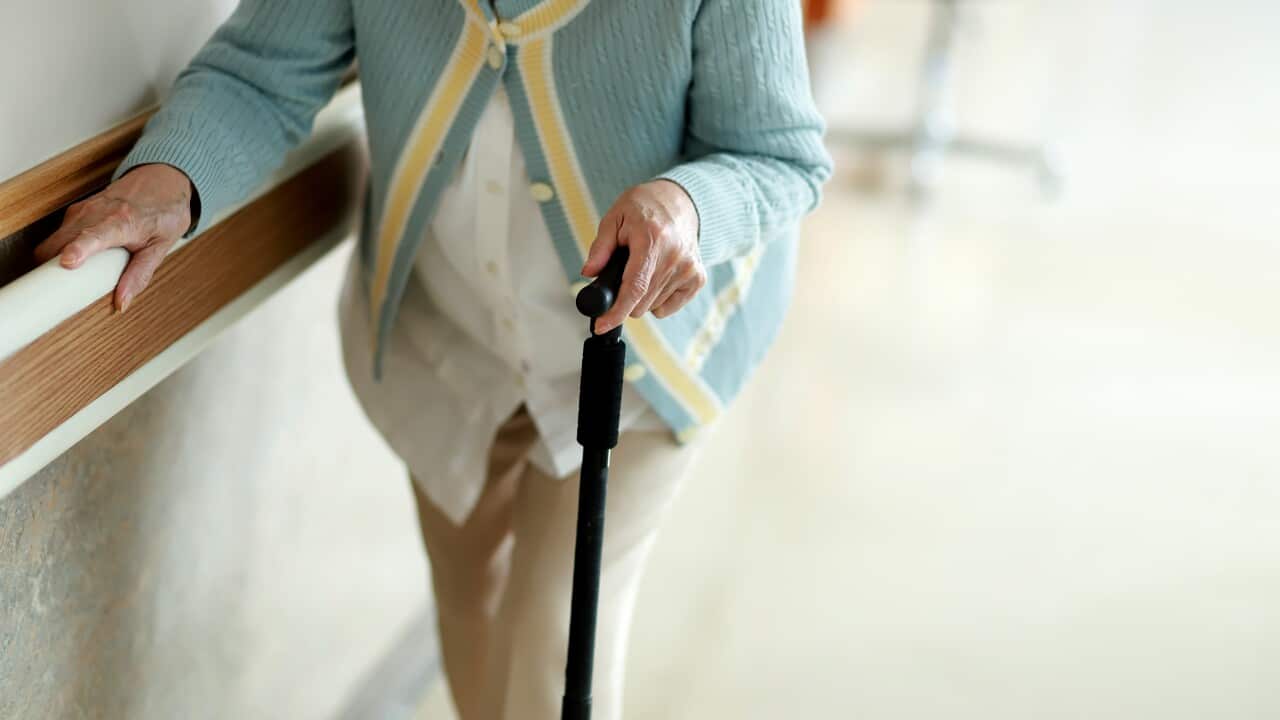 Senior woman walking with walking cane in