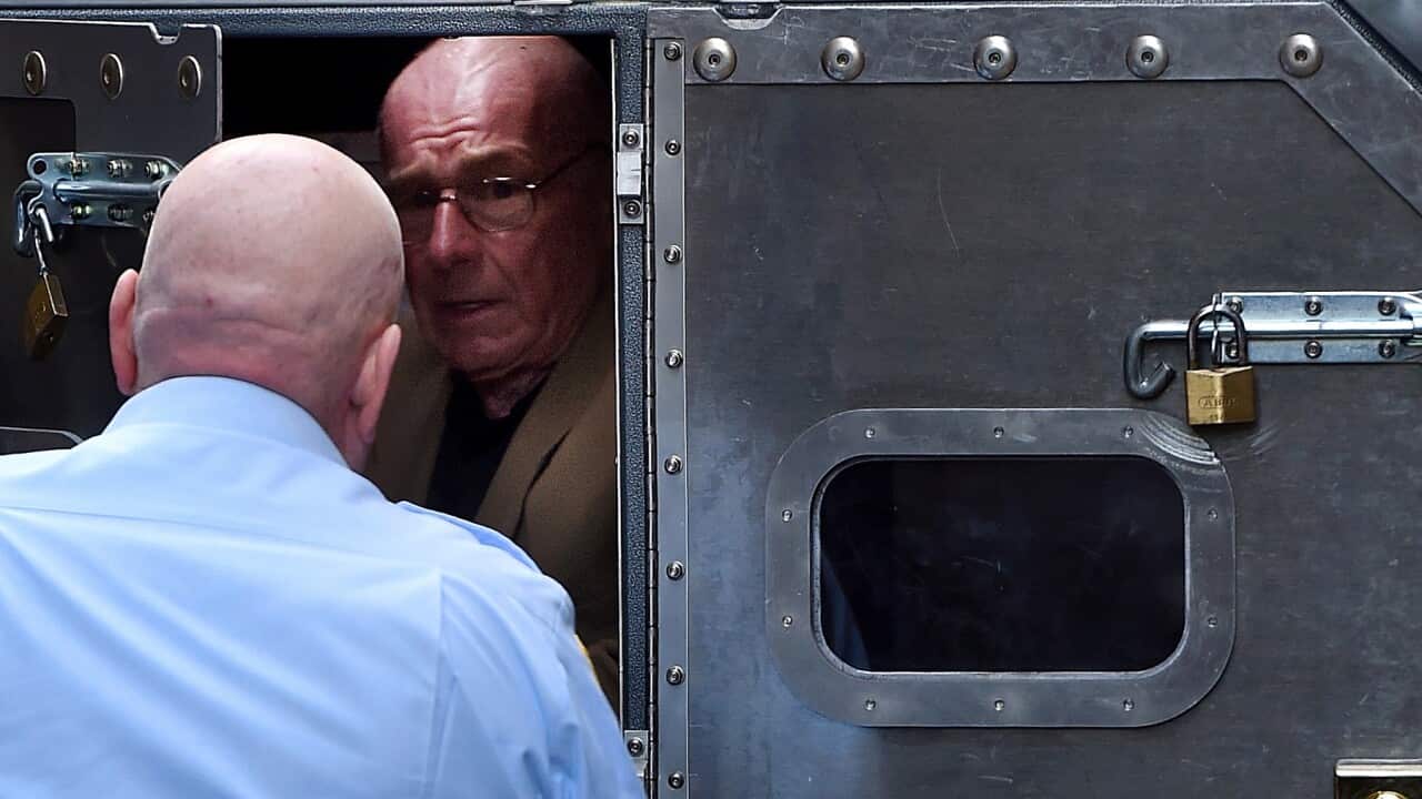 Former detective Roger Rogerson is escorted to a prison van in 2016 (AAP)