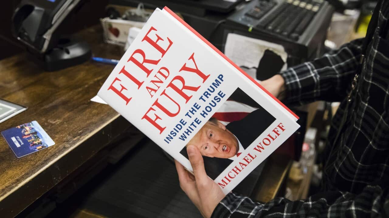 A salesperson with a copy of Fire and Fury: Inside the Trump White House at a store in Philadelphia.