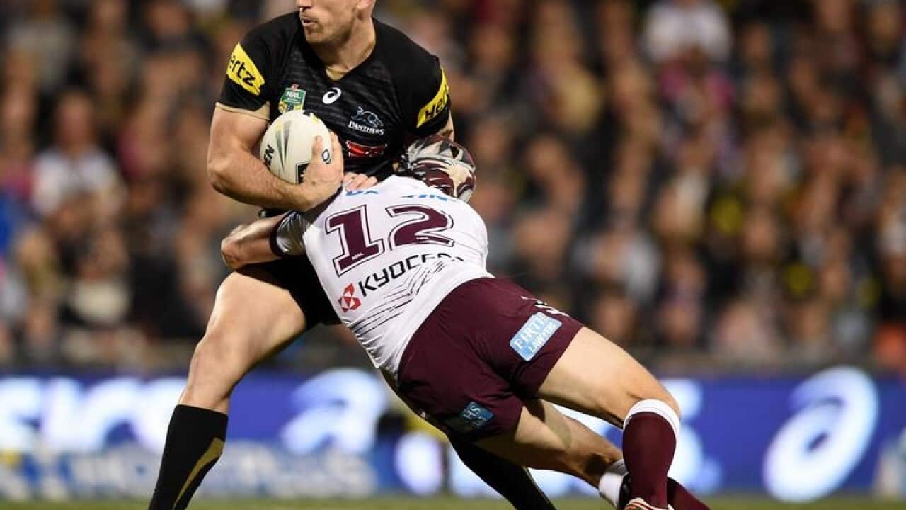 Bryce Cartwright of the Panthers is tackled by an opposition player.