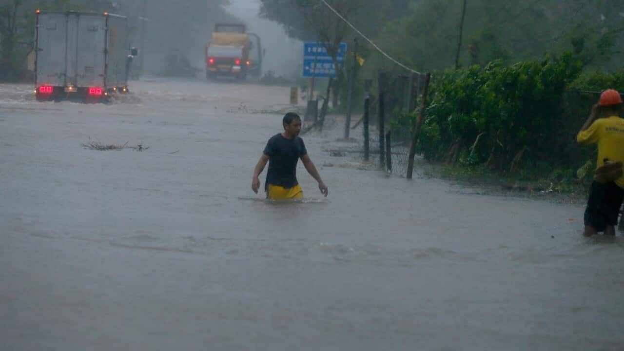 A man wades through a flooded highway at the height of Super Typhoon Haima that lashed the northern Philippines on Oct 20