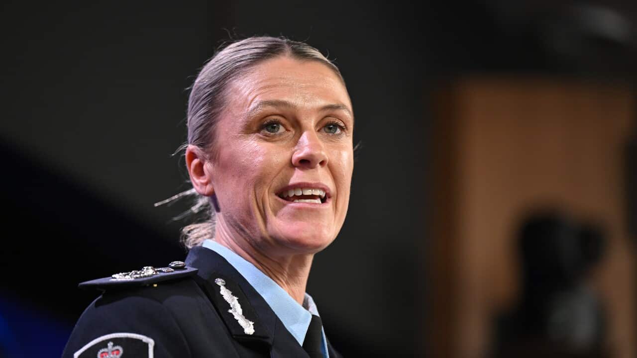 A woman in a police uniform mid-speech.
