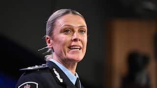 Krissy Barrett in a police uniform with her mouth open mid-speech.