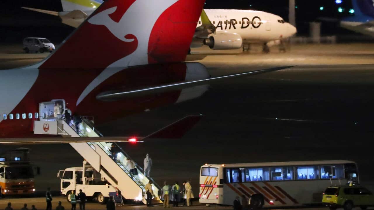 Passengers from the Diamond Princess board a Qantas airplane at Haneda airport