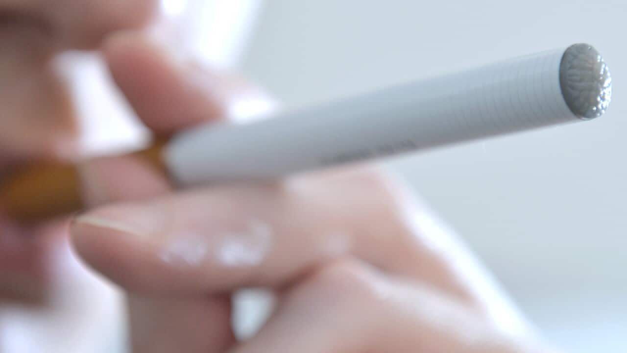 A person smokes an e-cigarette