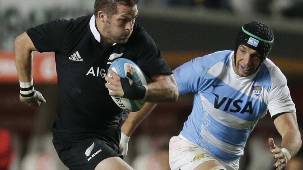 New Zealand's All Blacks Richie McCaw, center, runs with the ball