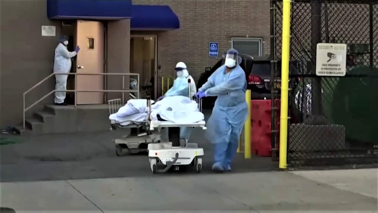 Workers bringing in two dead bodies to a temporary morgue in Brooklyn, USA