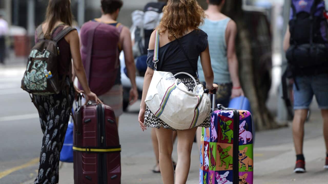 Backpackers walk through the streets of Brisbane