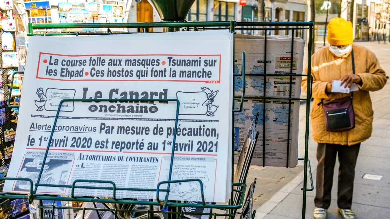 A newspaper called "Le Canard Enchaine" on a rack.