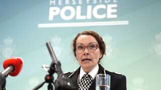Woman in police uniform speaking into microphone.