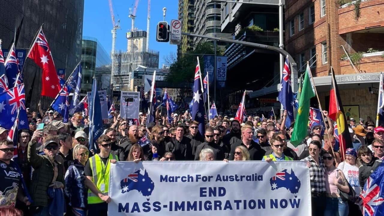 A large group of people holding a banner that says “March for Australia - end mass-immigration now“.