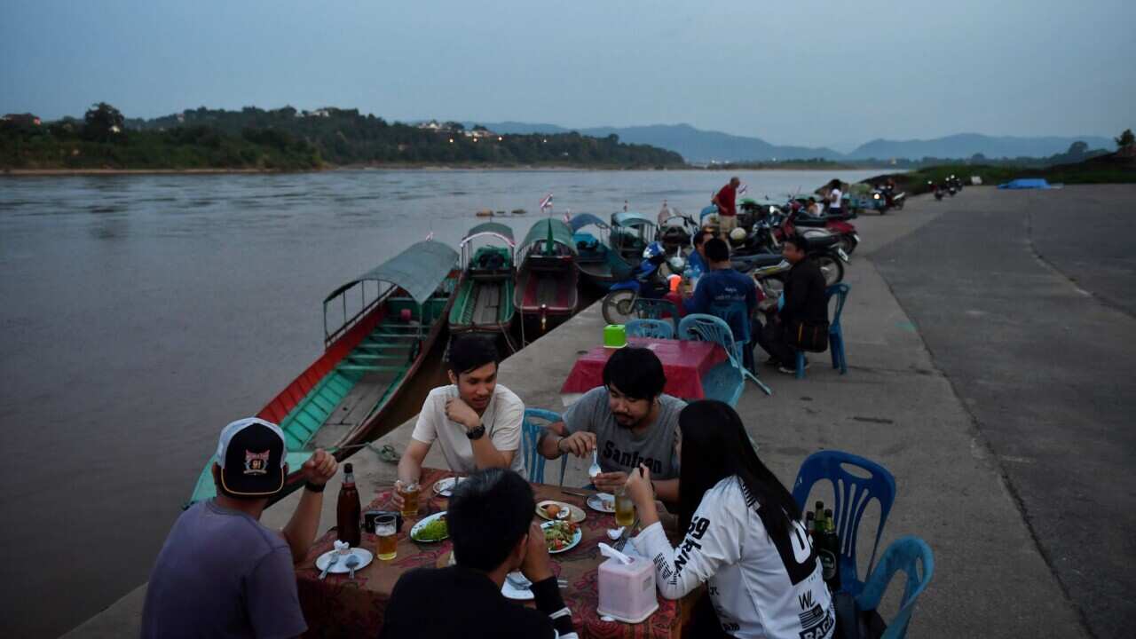 People eating on the bank of the Mekong River in Chiang Khong, Chiang Rai, Thailand opposite Boekeo provovince, Lao (LILLIAN SUWANRUMPHA - AFP via Getty)