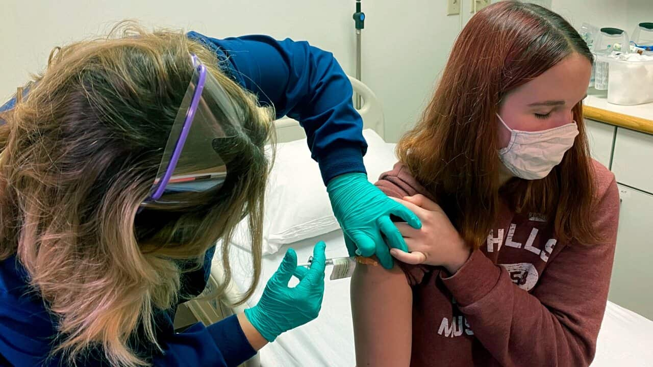 A research coordinator administers an injection to Katelyn Evans as part of clinical trial of Pfizer's COVID-19 vaccine at Cincinnati Childrens Hospital.